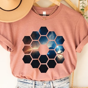 May include: A heather mauve t-shirt with a graphic of a honeycomb pattern filled with a nebula image.