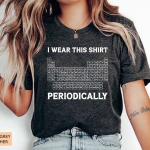 May include: Dark grey heather t-shirt with a white periodic table graphic and the text "I wear this shirt periodically".