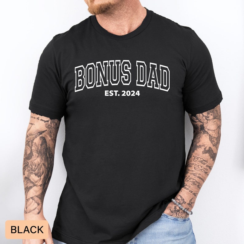 May include: Black t-shirt with white text that reads "Bonus Dad Est. 2024".
