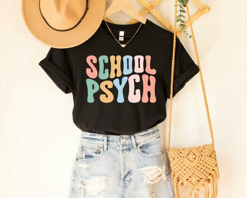 May include: Black t-shirt with the text "SCHOOL PSYCH" in colorful retro font.