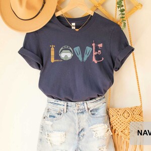 Peut inclure: T-shirt bleu marine avec un graphique d'&eacute;quipement de plong&eacute;e sous-marine &eacute;pellant le mot "LOVE".