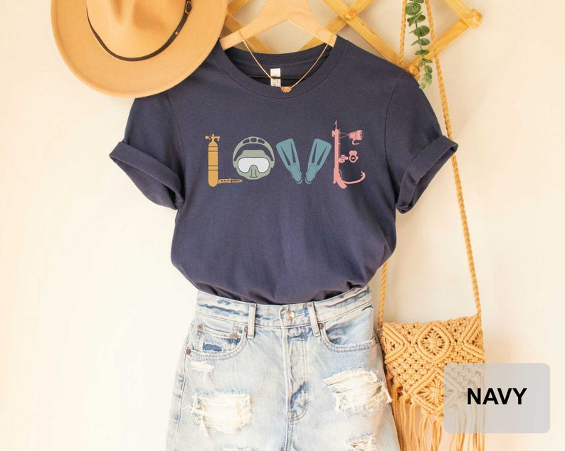 Peut inclure: T-shirt bleu marine avec un graphique d'&eacute;quipement de plong&eacute;e sous-marine &eacute;pellant le mot "LOVE".