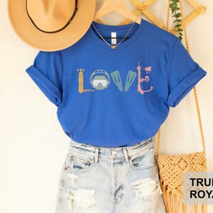 Peut inclure: Un t-shirt bleu royal avec un graphique d'&eacute;quipement de plong&eacute;e sous-marine qui &eacute;pelle le mot "LOVE".