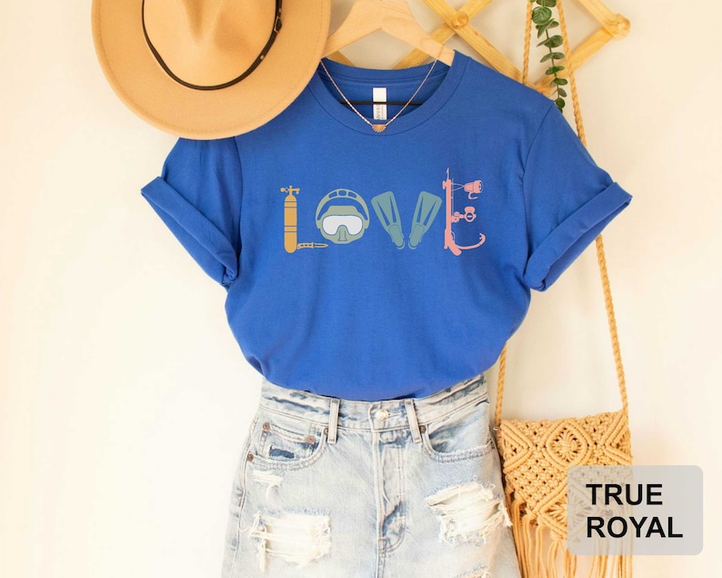 Peut inclure: Un t-shirt bleu royal avec un graphique d'&eacute;quipement de plong&eacute;e sous-marine qui &eacute;pelle le mot "LOVE".