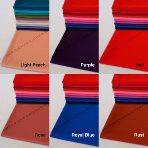 May include: A collection of fabric swatches in various colors, including light peach, purple, red, rose, royal blue, and rust. The swatches are stacked on top of each other and labeled with their respective colors.
