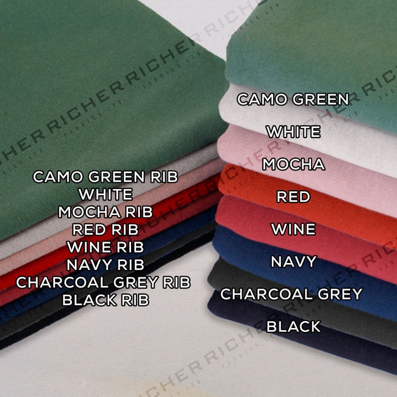 Op de afbeelding: Een stapel stofstalen in verschillende kleuren en texturen, waaronder camouflagegroen, wit, mokka, rood, wijn, marine, antracietgrijs en zwart. Elk staal heeft een label met de kleur en het type, zoals "Camo Green Rib" en "Black Rib".