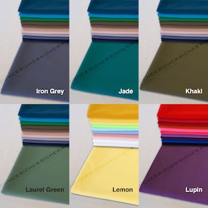 May include: A stack of fabric swatches in various colors, including iron grey, jade, khaki, laurel green, lemon, and lupin. Each swatch is folded and stacked on top of each other.