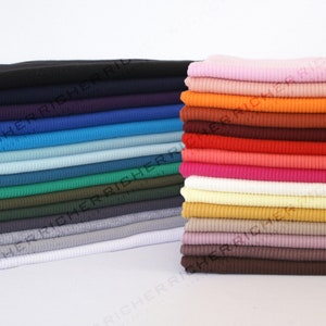 May include: A stack of 20 different coloured ribbed knit fabric swatches. The colours include black, navy, blue, teal, green, brown, grey, white, pink, orange, red, and more.