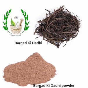 Op de afbeelding: Een close-up van een stapel bruine, gedroogde wortels, met het label "Bargad Ki Dadhi". Onder de wortels ligt een stapel bruin poeder met het label "Bargad Ki Dadhi powder".