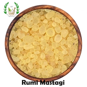 May include: A wooden bowl filled with small, light yellow, translucent resin pieces. The bowl is labeled "Rumi Mastagi".
