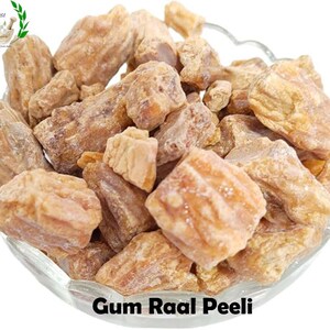 Puede incluir: Un bol lleno de Gum Raal Peeli, un tipo de fruta seca, en varios tamaños y formas. La fruta es de color marrón claro y tiene una apariencia ligeramente translúcida.