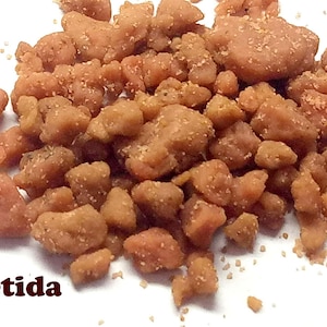 May include: Close-up of a pile of brown and orange asafetida resin pieces. The resin is a natural spice used in cooking.