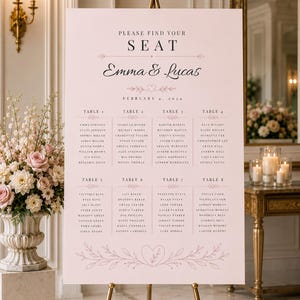 Può includere: Un tableau di nozze rosa chiaro su un cavalletto dorato. Il grafico recita "Please Find Your Seat" ed elenca i nomi di Emma e Lucas, con la data 4 febbraio 2024. I nomi degli ospiti sono elencati sotto i numeri dei tavoli.