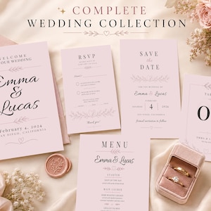 Può includere: Una collezione completa di matrimoni con biglietti d'invito, biglietti RSVP, un menu e segnaposto. I biglietti sono rosa chiaro con una scrittura elegante e accenti floreali. È presente anche un portagioie con due anelli e un sigillo di cera.