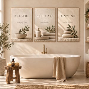 May include: Three rectangular wall art prints featuring beige backgrounds and black text. The first reads BREATHE, the second SELF CARE, and the third UNWIND. Each print displays imagery of stone bowls, olive branches, towels, and stacked stones.