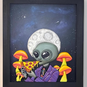 May include: A framed wall art piece featuring a gray alien with a moon-shaped head, wearing a purple suit and a patterned tie, eating a slice of pepperoni pizza. The background depicts a dark blue starry night sky with bright orange mushrooms.
