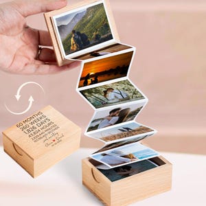 May include: A wooden photo box with a series of attached photos, displaying a couple in various settings. The box is open, revealing the photos, and has text that reads "60 months, 260 weeks, 1,826 days" and a date.