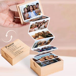 May include: A wooden photo box with a series of attached photos unfolding like an accordion. The box is made of light-colored wood and has the word "Pastor" and its definition printed on the side. The photos show groups of people.