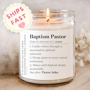 May include: A 9 oz natural soy wax candle in a clear glass jar with a white label featuring the text Baptism Pastor, a phonetic pronunciation, and a definition listing three points about guiding spiritual milestones and bringing grace to celebrations.