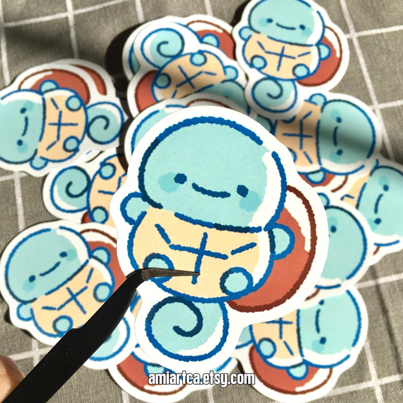 Pode incluir: Uma cole&ccedil;&atilde;o de autocolantes de desenhos animados com uma personagem azul clara semelhante a uma tartaruga com uma carapa&ccedil;a amarela e um rosto sorridente. Os autocolantes t&ecirc;m uma borda branca e um design de carapa&ccedil;a vermelho e castanho. O texto "amiartea.etsy.com" &eacute; vis&iacute;vel.