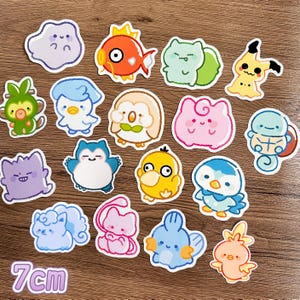 May include: A collection of fifteen die-cut vinyl stickers featuring colorful cartoon creatures in a hand-drawn style. Each sticker measures 7 cm. The characters include various shapes and colors like orange, blue, pink, green, and yellow.