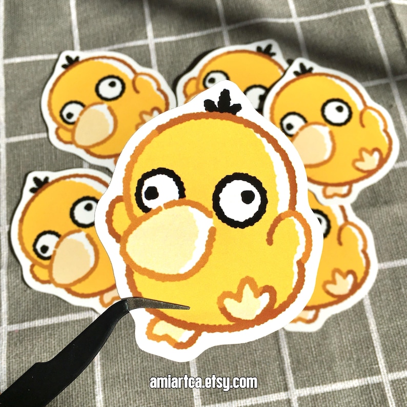 Pode incluir: Uma cole&ccedil;&atilde;o de adesivos de pato amarelo de desenho animado com olhos pretos e brancos e detalhes em laranja. Os adesivos est&atilde;o em uma superf&iacute;cie xadrez cinza e branca. O texto "amiartea.etsy.com" &eacute; vis&iacute;vel.