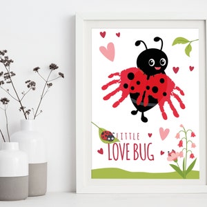 Op de afbeelding: Een wit frame met een kleurrijke print van een lieveheersbeestje met rode vleugels en zwarte stippen. Het lieveheersbeestje heeft een zwart hoofd met witte ogen en een glimlach. De tekst "Little Love Bug" staat in rode letters onder het lieveheersbeestje. Er zijn roze hartjes en groene bladeren rondom het lieveheersbeestje.