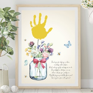 May include: A yellow handprint with a bouquet of flowers in a glass jar with a pink ribbon. The flowers are pink, purple, white, and green. The text reads: "Thank you for helping me bloom, and stay wild and free. And making my life as happy as can be. The pretty flower that you can see was made for you, just by me. My little fingers painted the flower part. Showing love from all my heart."