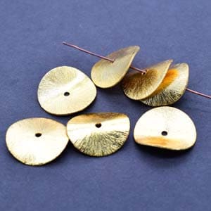 May include: Six gold-coloured metal sequins with a slightly wavy, textured surface. Each sequin has a small hole in the centre.