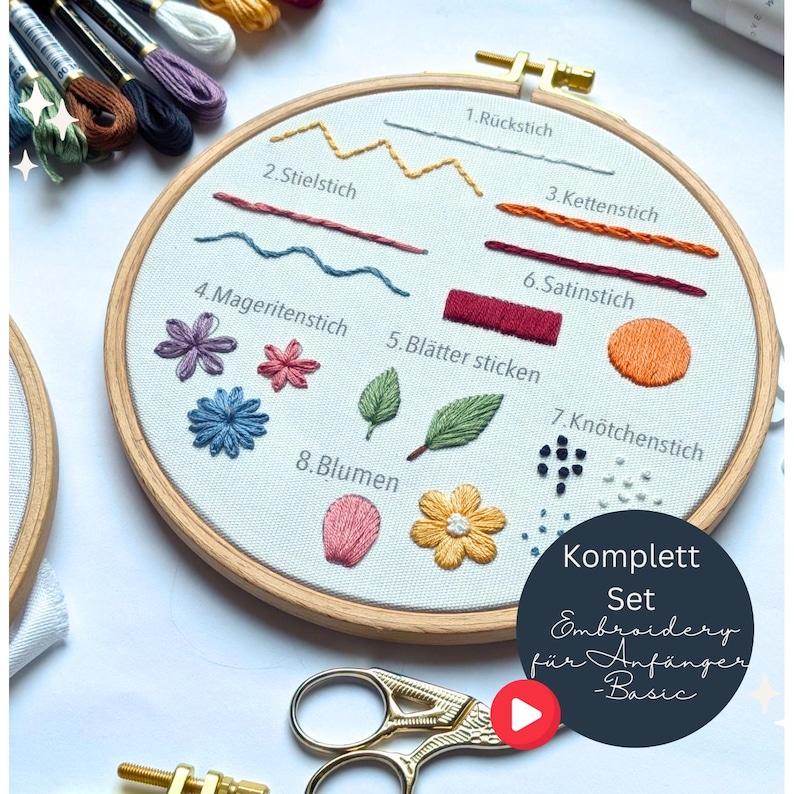 May include: A wooden embroidery hoop with a white fabric featuring various embroidery stitches and floral designs. The text "Komplett Set Embroidery f&uuml;r Anf&auml;nger - Basic" is visible. A pair of gold scissors and embroidery floss are also in the image.