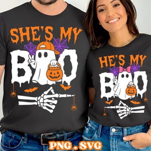 May include: Black Halloween t-shirts with matching designs. One shirt says "She's My Boo" with a ghost wearing a hat and holding a pumpkin bucket. The other shirt says "He's My Boo" with a ghost wearing a bow and holding a pumpkin bucket.