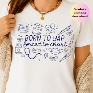 May include: White t-shirt with a navy blue medical-themed design. The design includes illustrations of medical tools and the text "BORN TO YAP forced to chart". A pink and yellow circle with the text "3 colors instant download" is in the upper right.