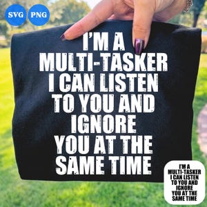 Peut inclure: Un t-shirt noir avec un texte blanc au style vieilli qui indique : I'M A MULTI-TASKER I CAN LISTEN TO YOU AND IGNORE YOU AT THE SAME TIME. Le motif est centré sur le tissu, avec des lettres nettes et audacieuses qui ressortent sur le fond sombre.