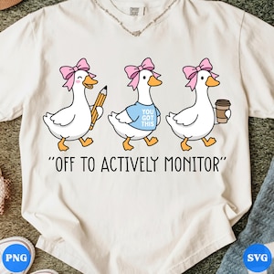 May include: Cream-colored t-shirt featuring three cartoon geese with pink bows. The geese are depicted with a pencil, a shirt that says "YOU GOT THIS", and a coffee cup. The text "OFF TO ACTIVELY MONITOR" is printed below the geese.