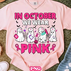 Peut inclure: T-shirt rose clair avec l'inscription "IN OCTOBER WE WEAR PINK" en rose. Le motif présente des fantômes infirmiers de dessins animés avec des objets médicaux et des rubans roses. Col rond.