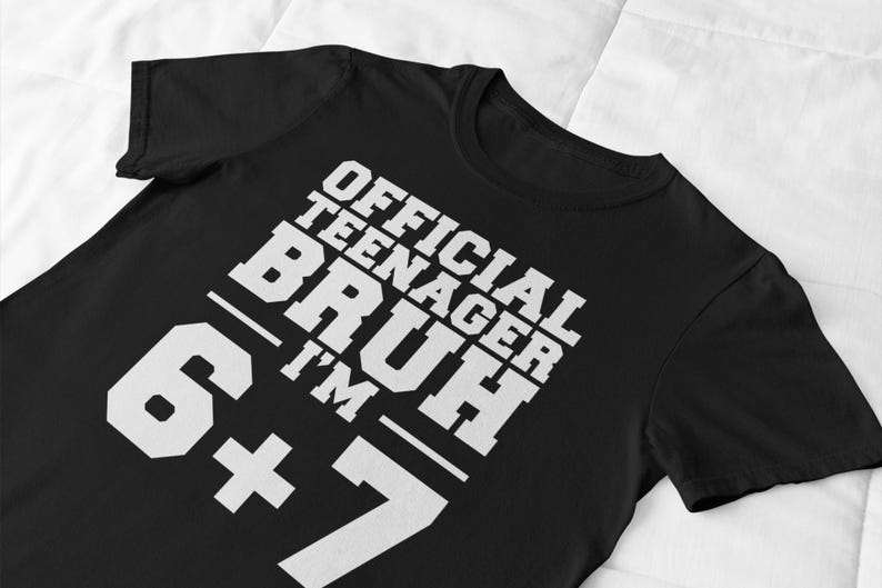 May include: Black t-shirt with the text "OFFICIAL TEENAGER BRUH I'M 6+7" in white, bold, block letters. The shirt is made of a soft material and is suitable for casual wear.