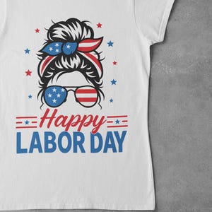 May include: White t-shirt with a graphic design for Labor Day. The design features a woman's silhouette with a red, white, and blue headband and sunglasses. The text "Happy Labor Day" is in red and blue.