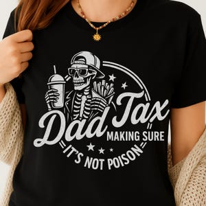 May include: Black t-shirt with a white graphic of a skeleton wearing sunglasses and a baseball cap, holding a drink and fries. Text reads "Dad Tax Making Sure It's Not Poison."