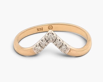 May include: A V-shaped ring crafted from yellow gold with a matte finish. The center point features a white gold setting inlaid with five small, round, clear diamonds. The interior of the band is stamped with the text 14K and a small circular hallmark.