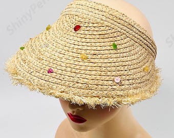 May include: A straw sun hat with a wide brim and a fringe trim. The hat is decorated with colorful beads.