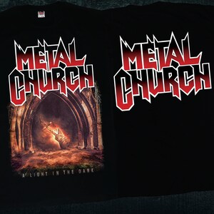 May include: Black t-shirt with a red and white "Metal Church" logo on the front and back. The front also features a graphic of a burning church with the text "A Light in the Dark".