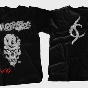 May include: Black t-shirt with a white graphic of a skull with the text "CANCERSLUG" above it and "WHORE" below it. The back of the shirt has a white graphic of a stylized "C".