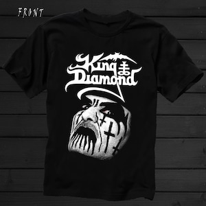May include: Black t-shirt with a white graphic of a man's face with black and white makeup and the text "King Diamond" above the face.