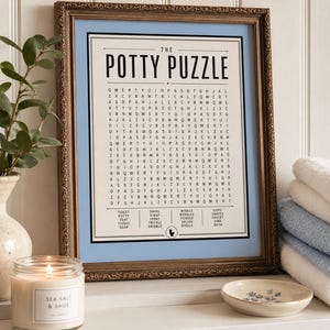 K&ouml;nnte beinhalten: Ein gerahmtes Wortsuchr&auml;tsel mit dem Titel The Potty Puzzle und einem hellblauen Rand. Der Druck zeigt ein Buchstabenraster und eine Wortliste mit Begriffen wie toilet, potty, seat, tissue, soap, swirl, rinse, spray, trickle, dribble, wiggle, bubbles, puddle, splish, giggle, oops, undies, faucet, sink und bath sowie ein kleines Toilettensymbol am unteren Rand.