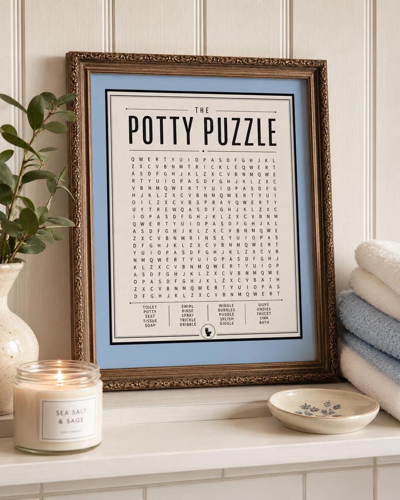 K&ouml;nnte beinhalten: Ein gerahmtes Wortsuchr&auml;tsel mit dem Titel The Potty Puzzle und einem hellblauen Rand. Der Druck zeigt ein Buchstabenraster und eine Wortliste mit Begriffen wie toilet, potty, seat, tissue, soap, swirl, rinse, spray, trickle, dribble, wiggle, bubbles, puddle, splish, giggle, oops, undies, faucet, sink und bath sowie ein kleines Toilettensymbol am unteren Rand.