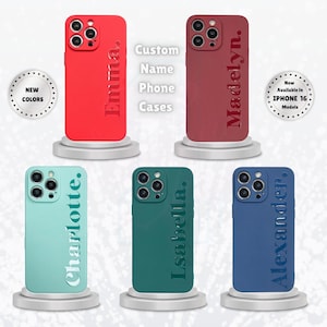 May include: Six different iPhone cases with custom names printed on them. The cases are red, green, blue, and turquoise. The text on the cases reads "Emma", "Madelyn", "Charlotte", "Isabella", "Alexander", and "Now Available in iPhone 16 Models".
