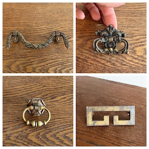 May include: A collection of four distinct metal drawer pulls in various antique brass finishes. The set includes a curved bail pull with leaf detailing, a decorative drop pull, a circular ring pull, and a rectangular geometric pull design.