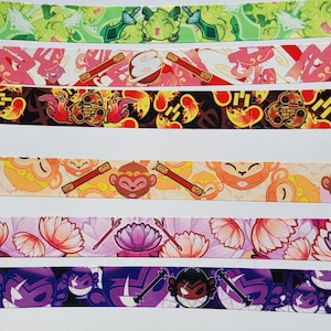Könnte beinhalten: Fünf verschiedene Washi Tapes mit bunten Designs. Das erste Band hat ein grün-weißes Design mit einer Comicfigur. Das zweite Band hat ein rosa-weißes Design mit einer Comicfigur. Das dritte Band hat ein schwarz-oranges Design mit einer Comicfigur. Das vierte Band hat ein gelb-oranges Design mit einer Comicfigur. Das fünfte Band hat ein lila-schwarzes Design mit einer Comicfigur.