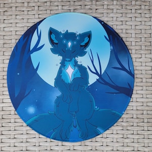 May include: Round blue mousepad featuring a stylized fox-like creature with closed eyes, adorned with stars. The background depicts a full moon and silhouetted trees. The color palette includes shades of blue and white.