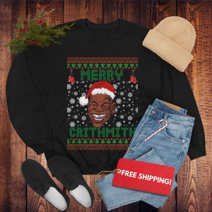 May include: Black Christmas sweater with a green, red, and white pattern. The sweater features a cartoon image of a man wearing a Santa hat and the text "Merry Critthmith".